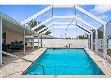 A sparkling screened-in pool with brick pavers offers a refreshing oasis for relaxation and recreation at 4168 Harbor Blvd, Port Charlotte, FL 33952