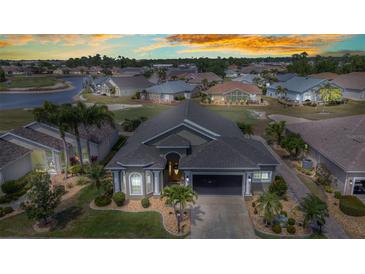 Stunning front elevation showing the lush landscaping and well-manicured lawn in this lovely gated community at 24260 Westgate Blvd, Port Charlotte, FL 33980