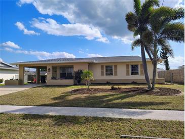 Charming single-story home with a well-maintained lawn, mature palms and a convenient covered carport at 6327 Fabian Rd, North Port, FL 34287