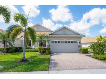 Charming single-story home featuring a paved driveway, lush landscaping, and an attached two-car garage at 1940 Scarlett Ave, North Port, FL 34289