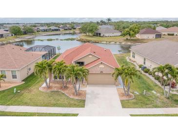 A beautiful aerial view of the house including a lake view and palm trees at 2699 Suncoast Lakes Blvd, Punta Gorda, FL 33980