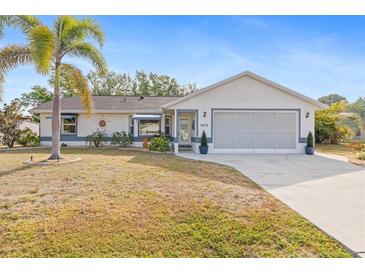 Charming single-story home with a well-maintained lawn, palm tree, and attached two-car garage at 3078 Mancini Ter, Punta Gorda, FL 33983
