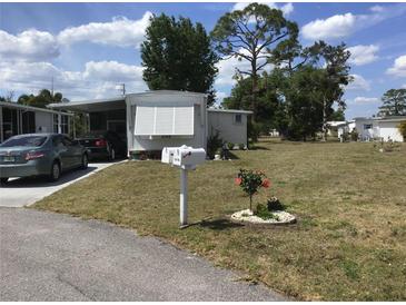 Charming home featuring a covered carport and well-maintained lawn with flower bed at 5048 Palena Blvd, North Port, FL 34287
