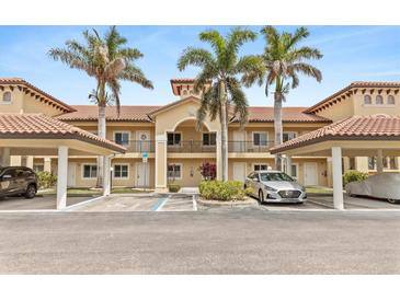 Inviting condo building with palm trees and covered parking spaces, perfect for coastal living at 7196 N Plum Tree # 323, Punta Gorda, FL 33955