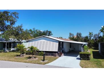 Cozy single-story home with a carport and well-maintained landscaping, perfect for comfortable living at 861 Seabrooke Dr, Englewood, FL 34223