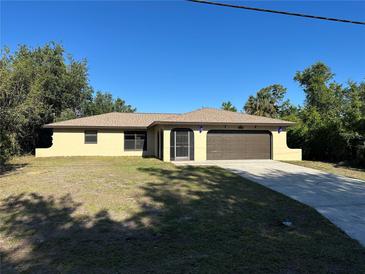 Charming single-story home featuring a well-maintained lawn and an attached two-car garage at 1022 Waterside St, Port Charlotte, FL 33952