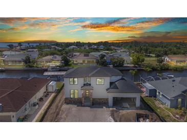 Stunning waterfront home featuring modern design with stone accents and a convenient covered parking area at 12387 Minot Ave, Port Charlotte, FL 33981