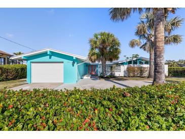 Charming home with a vibrant blue exterior, neat landscaping, and welcoming curb appeal at 1960 W Marion Ave, Punta Gorda, FL 33950