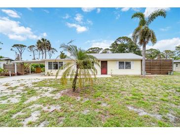 Charming single-story home with a light yellow exterior, a carport, and mature palm trees in the front yard at 217 Palm E Ave, Nokomis, FL 34275