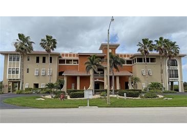 Elegant multi-story condo building featuring lush landscaping and a terracotta roof, offering luxurious living at 3311 Purple Martin Dr # 126, Punta Gorda, FL 33950