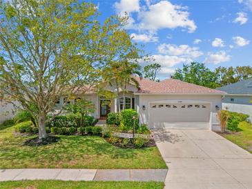 Charming single-story home featuring a two-car garage, lush landscaping, and a well-manicured lawn at 7344 Arrowhead Run, Lakewood Ranch, FL 34202