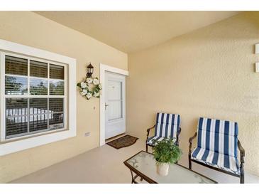 Inviting front porch with seating, decorative wreath, and secure storm door entry at 1235 Saxony Cir # 5202, Punta Gorda, FL 33983