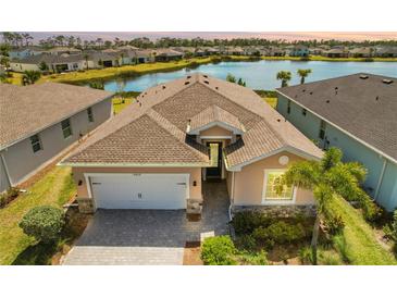 Inviting single-Gathering home featuring a neutral color scheme, well-manicured landscaping, and a picturesque lake in the backyard at 43839 Seedling Ter, Punta Gorda, FL 33982