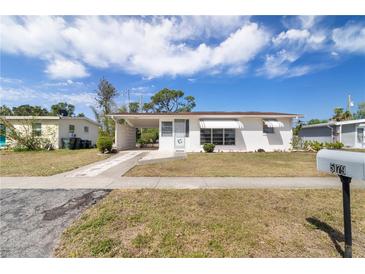 Charming single story home featuring a front lawn and a white exterior, complemented by a covered carport at 5179 Grobe St, North Port, FL 34287