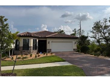 Beautiful single-story home with a well-manicured lawn and paver driveway at 1263 Cicely Ct, North Port, FL 34289