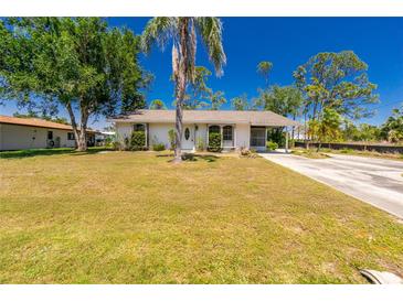 Charming single-story home with a well-maintained lawn and mature trees at 2690 Auburn Blvd, Port Charlotte, FL 33948