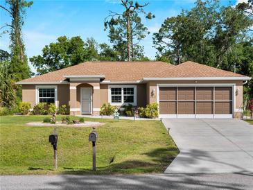 Charming single-story home featuring a well-manicured lawn and a two-car garage at 3621 Jade St, North Port, FL 34288