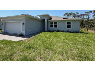 Charming single-story home featuring a well-maintained lawn and an attached two-car garage at 369 Biltmore St, Port Charlotte, FL 33953