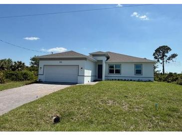 Beautiful single-story home with a well-maintained lawn and a two-car garage at 7474 Manville Ter, Port Charlotte, FL 33981