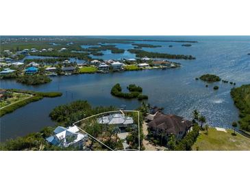 Waterfront home showcasing the community's stunning bay view surrounded by lush landscaping at 24139 Jolly Roger Blvd, Punta Gorda, FL 33955