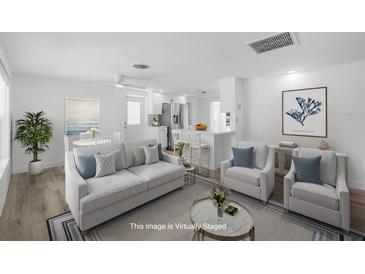 Bright open-concept living room showcasing a modern design with fresh, white interior and an open layout to the kitchen at 1020 Drury Ln, Englewood, FL 34224