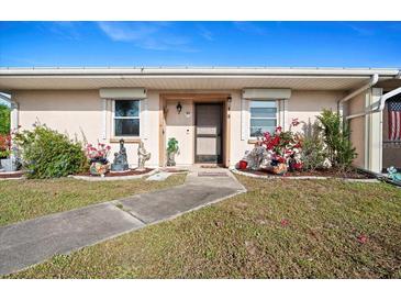 Charming front entrance featuring a well-manicured lawn and inviting doorway with decorative plants at 25068 Harborview Rd # 1B, Punta Gorda, FL 33980