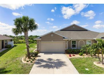 Charming single-Gathering home featuring a two-car garage, lush landscaping, and a well-maintained lawn at 7209 W Lenox Cir, Punta Gorda, FL 33950