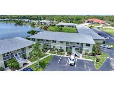 An exterior view of a condo building with balconies, green landscaping and parking at 25225 Rampart Blvd # 1607, Punta Gorda, FL 33983