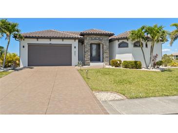 Charming single-Gathering home features a tile roof, an attached garage, and a well-manicured lawn at 4001 La Costa Island Ct, Punta Gorda, FL 33950