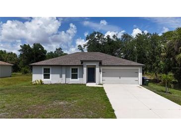 Charming single-story home with a well-maintained lawn and attached two-car garage at 4127 Snowdrop St, North Port, FL 34288