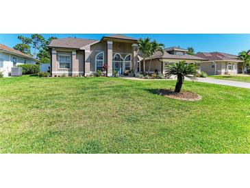 Expansive front yard featuring a well-manicured lawn and meticulously maintained landscaping at 420 Wabash Ter, Port Charlotte, FL 33954
