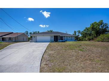 Charming single-story home featuring an attached two-car garage and a well-manicured lawn on a sunny day at 7225 Sea Mist Dr, Port Charlotte, FL 33981