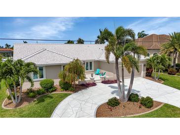 Beautifully landscaped front yard features a unique driveway and tropical foliage at 859 Napoli Ln, Punta Gorda, FL 33950