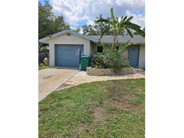 Charming single-story home with a well-maintained front yard and attached garage at 1457 Sheehan Blvd, Port Charlotte, FL 33952