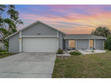 Single-story home boasts a large garage door, well-maintained lawn, and welcoming curb appeal at 242 Seminole Nw Blvd, Port Charlotte, FL 33952