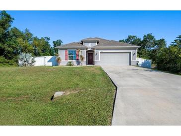 Charming single-story home boasts a well-manicured lawn, two car garage, and inviting curb appeal at 3476 Brewster Rd, North Port, FL 34288