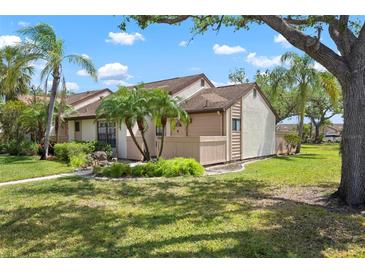 Charming exterior view showcases a well-manicured lawn, complemented by lush tropical landscaping, including mature palm trees at 5390 Brassy Loop, North Port, FL 34287
