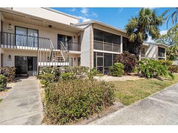 Two-story condo building featuring lush landscaping, screened-in lanais, and a well-maintained exterior at 5416 Swift Rd # 27, Sarasota, FL 34231