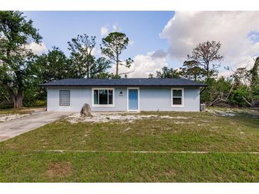 Charming single-story home featuring a well-manicured lawn and a bright blue front door at 6329 David Blvd, Port Charlotte, FL 33981