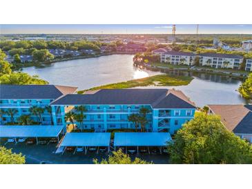 Beautiful view of aqua condo buildings with covered parking and a tranquil lake in the background at 19375 Water Oak Dr # 106, Port Charlotte, FL 33948
