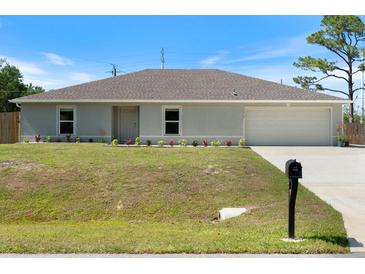 Charming single-story home with a well-manicured lawn and a two-car attached garage, providing curb appeal at 22010 Seyburn Ter, Port Charlotte, FL 33954
