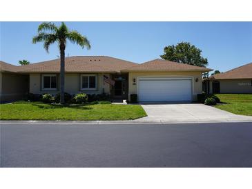 Charming single-story home featuring a well-manicured lawn and an attached two-car garage at 24141 Green Heron Dr # 23, Punta Gorda, FL 33980