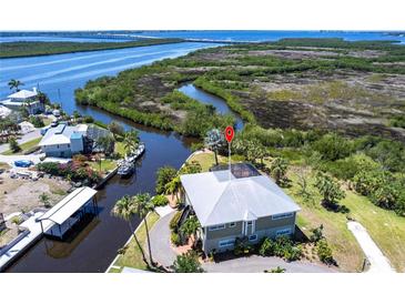 Stunning aerial view of waterfront home, lush landscaping, private dock, and picturesque river access at 3712 Balboa Ct, Punta Gorda, FL 33983