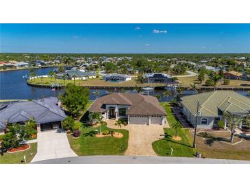Stunning waterfront property showcasing lush greenery, a boat dock, and a beautiful neighborhood setting at 4174 Perch Cir, Port Charlotte, FL 33948