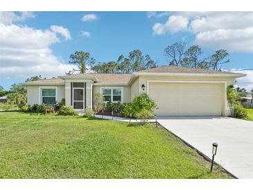 Charming single-story home features a well-manicured lawn, inviting front porch, and a convenient two-car garage at 4463 Cromey Rd, North Port, FL 34288