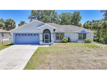 Charming single-story home with a blue garage door, screened porch, and well-maintained front yard at 5640 Burdette Ter, North Port, FL 34287