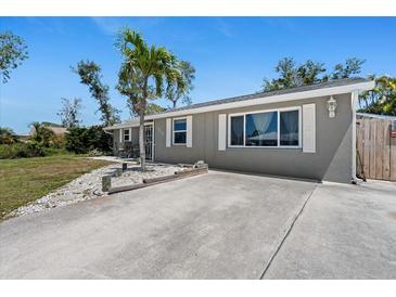 Charming single-story home featuring a spacious driveway and a well-maintained lawn with a young palm tree at 1249 Indus Rd, Venice, FL 34293