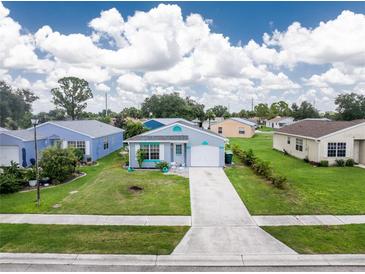 Charming single-story home with a well-manicured lawn and a driveway leading to the garage at 20016 Sancraft Ave, Port Charlotte, FL 33954