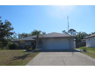 Charming single-story home featuring a well-maintained lawn and a two-car garage at 296 Milford St, Port Charlotte, FL 33953