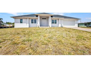 Charming single-story home with a modern design, attached garage, and front yard with ample lawn space at 4213 Gardner Dr, Port Charlotte, FL 33952
